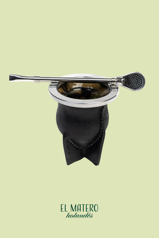 Black leather mate with stainless steel straw on a light green background, featuring 'El Matero' branding.